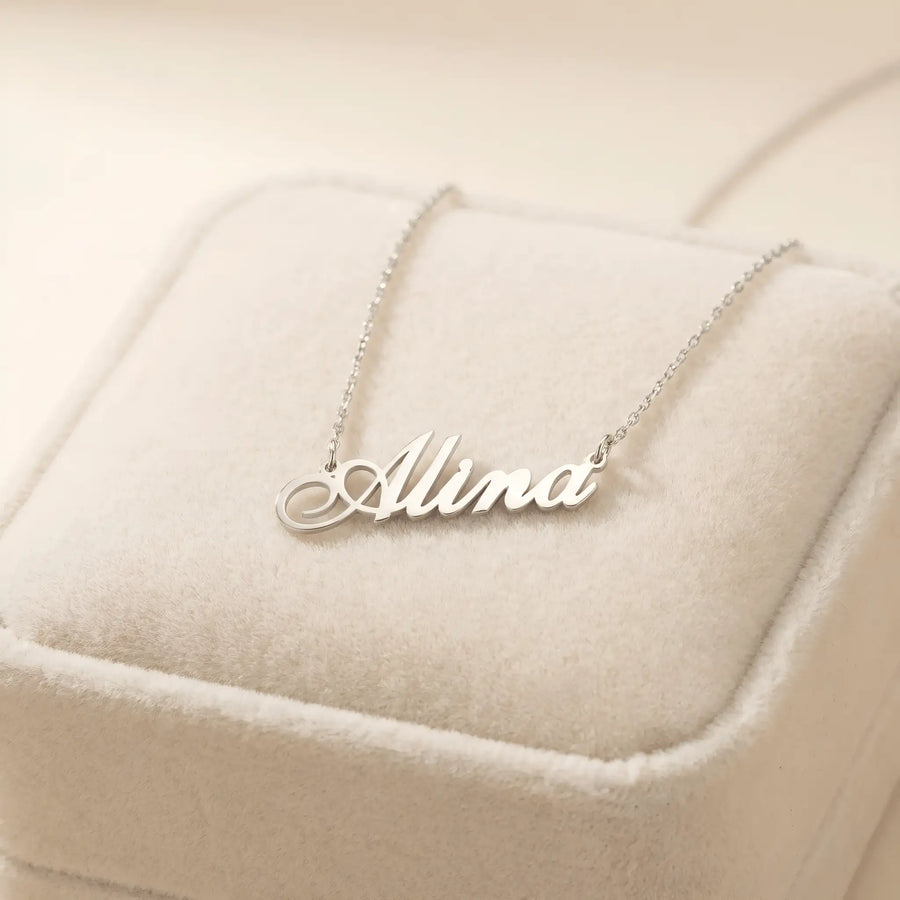 Lănțișor argint 925 rodiat cu numele Alina, pandantiv decupat 34.5x10 mm font cursiv, lanț anchor 46 cm pe cutie velvet bej cu cusătură decorativă
