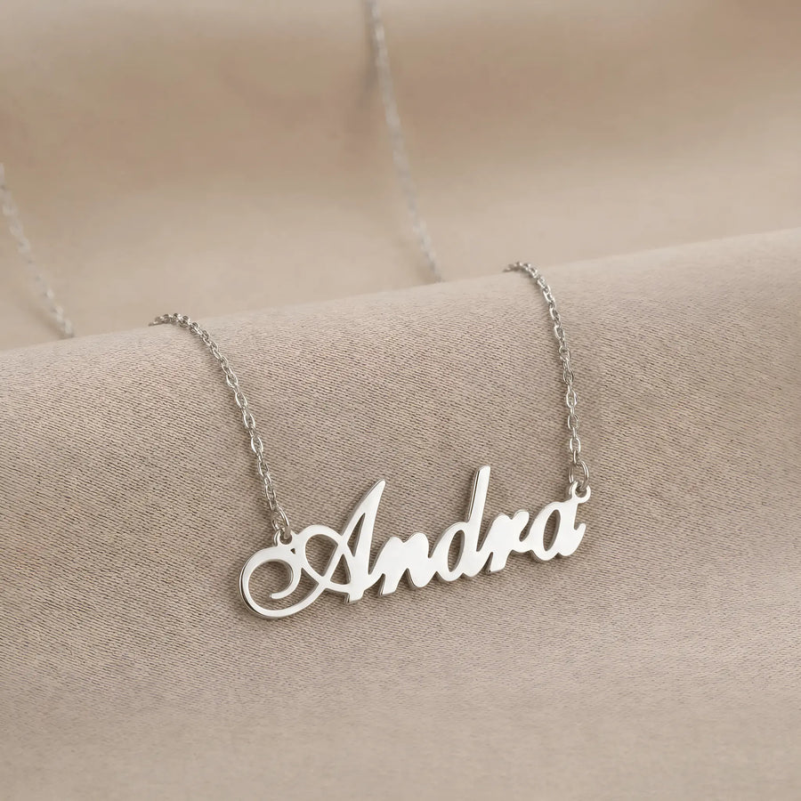 Lănțișor argint 925 rodiat personalizat cu numele Andra decupat în scriere cursivă elegantă pe lanț subțire alb-platinat, ambianță textilă caldă