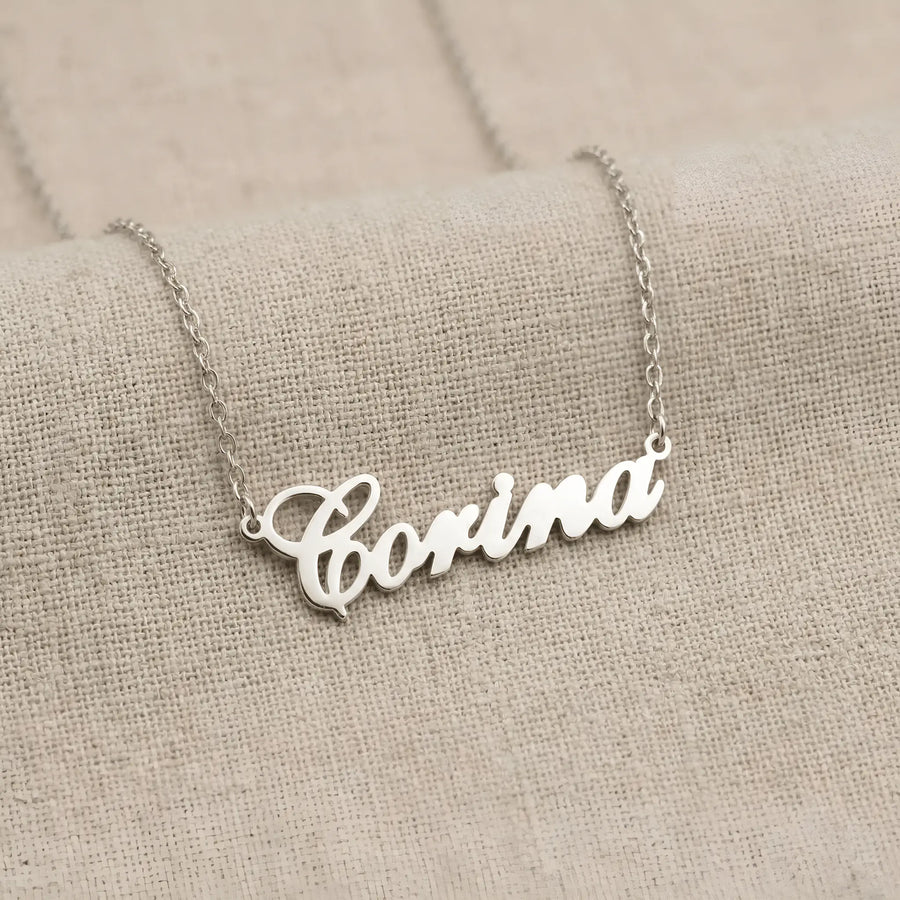 Lănțișor argint 925 rodiat cu numele Corina, pandantiv decupat 38.5x10 mm font cursiv inițiala C deschisă, lanț anchor 46 cm pe textil natural