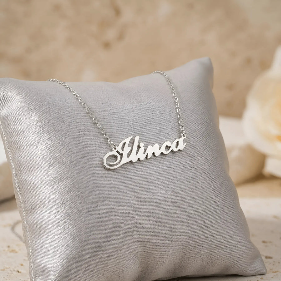 Lănțișor argint 925 rodiat personalizat cu numele Ilinca decupat în scriere cursivă elegantă pe pernuță gri satin cu trandafir, lanț subțire alb-platinat