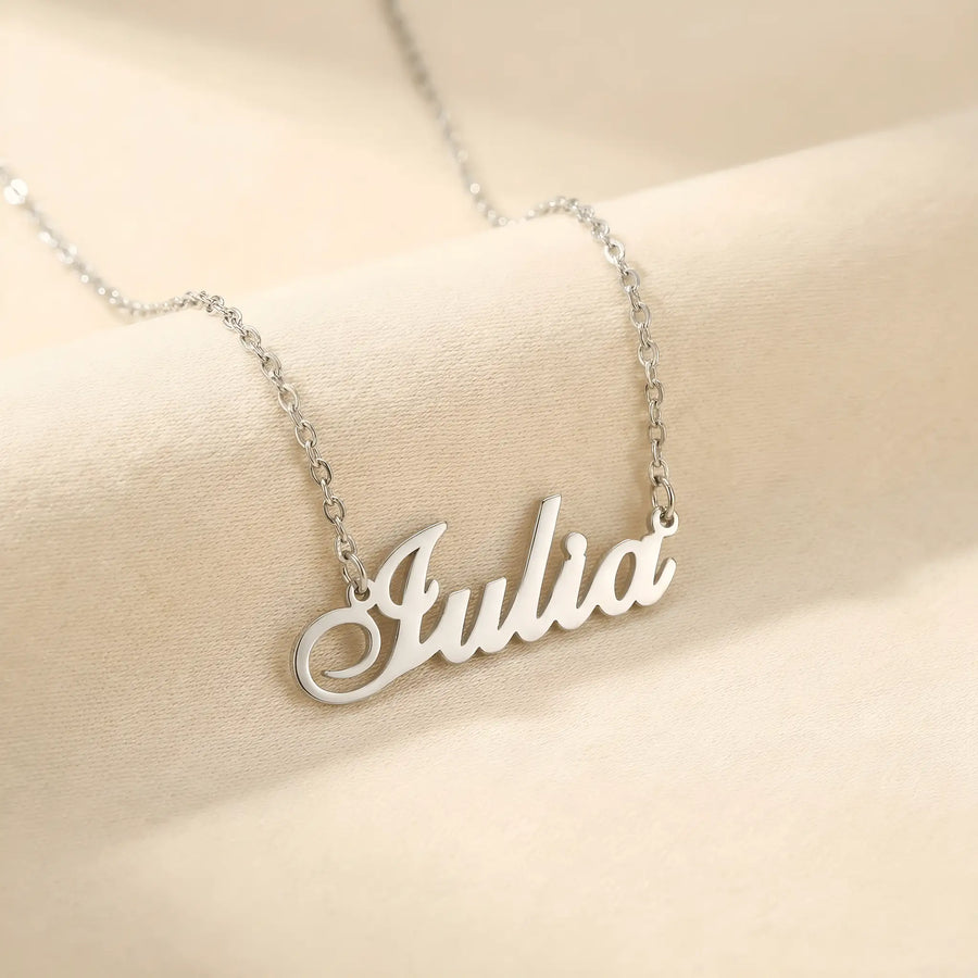 Lănțișor argint 925 rodiat personalizat cu numele Iulia decupat în scriere cursivă elegantă cu I cu coadă caligrafică pe drapaj satin crem, lanț subțire alb-platinat