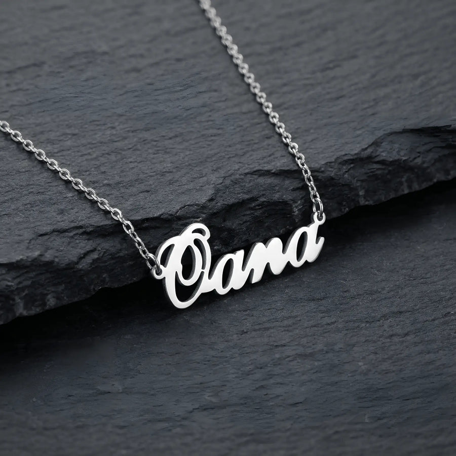 Lănțișor argint 925 rodiat personalizat cu numele Oana decupat în scriere cursivă elegantă cu O mare cu buclă pe stâncă neagră de ardezie, lanț subțire alb-platinat