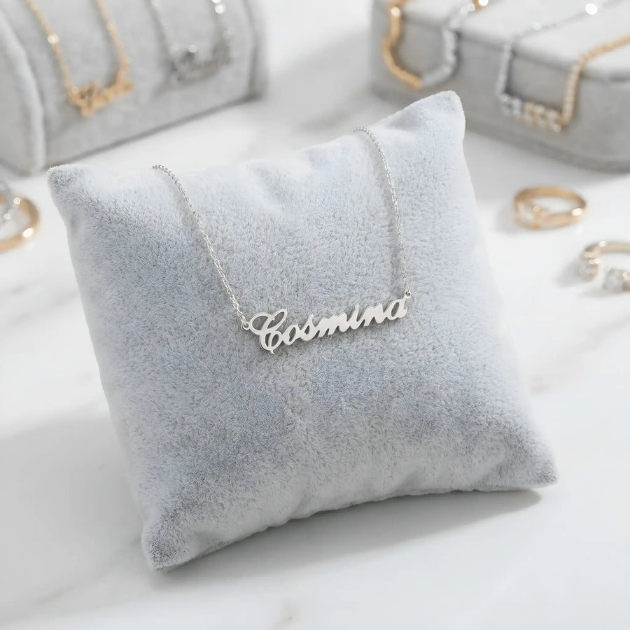 Lănțișor argint 925 rodiat personalizat cu numele Cosmina decupat în scriere cursivă elegantă pe pernuță gri velvet, ambianță jewelry display alb-marmorat