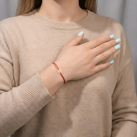Detaliu inimă aur 14K cu lăbuță cățel pe șnur roșu împletit