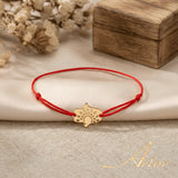 Brățară aur 14K cu șnur roșu și pandantiv Mâna Hamsa 12×9.5 mm cu decor floral granulat