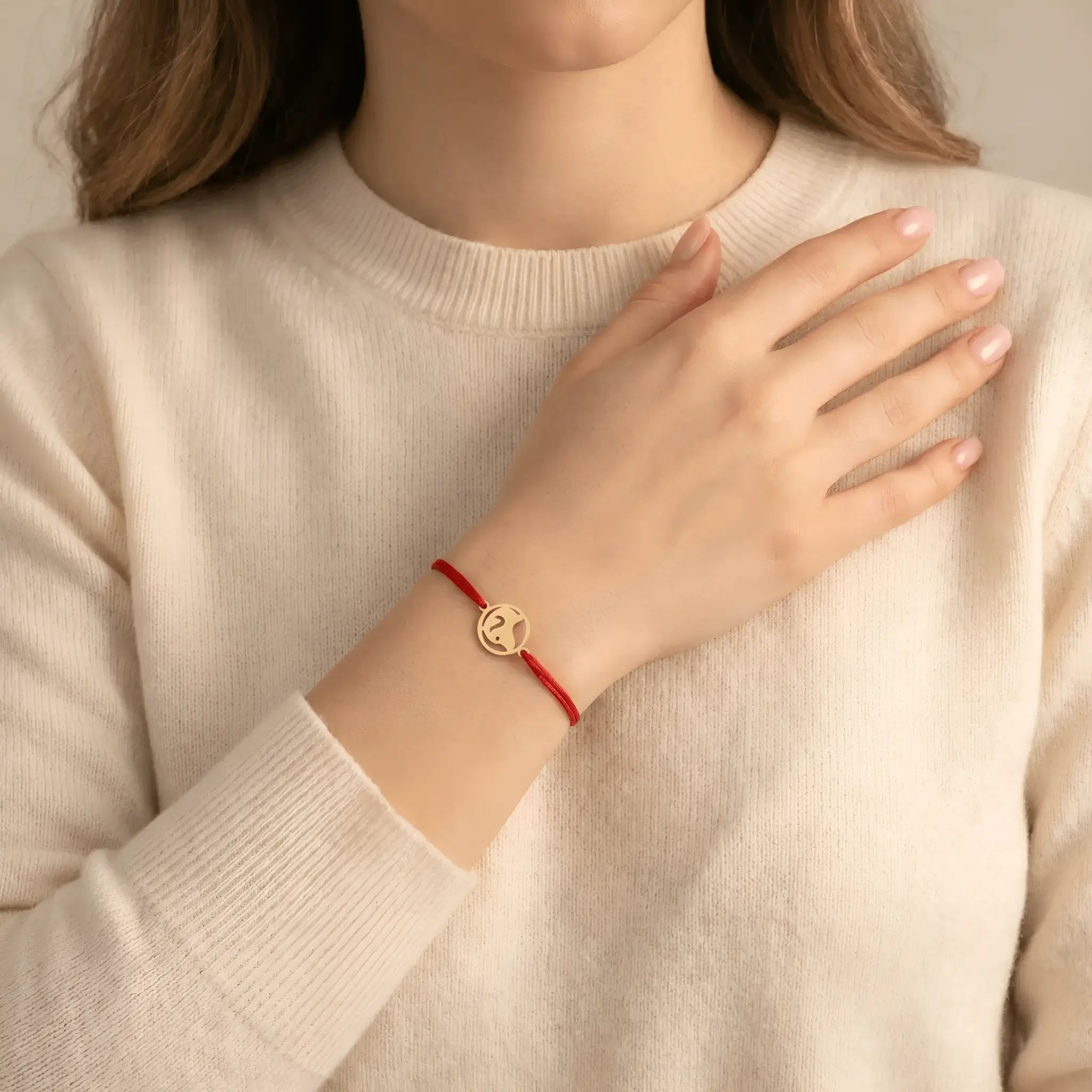 Brățară aur 14K cu bănuț cățel și șnur roșu purtată pe încheietură damă