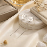 Cercei argint 925 rodiat threader cu disc lună-soare 10mm — pereche pe placă marmură albă rotundă cu satin crem și flori uscate gypsophila pe fundal, decupaj soare cu raze și arc lunar lateral, lanț subțire 6cm cu tijă-bară, finisaj oglindă alb-platinat