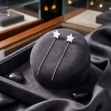 Cercei argint 925 rodiat threader cu stea mare plină 8,5mm — pereche pe pernă rotundă velvet gri-grafit cu satin gri închis pe fundal, pietre semi-prețioase obsidian negre, vitrina cu bijuterii pe lateral, lanț 6cm cu tijă-bară, finisaj oglindă alb-platinat