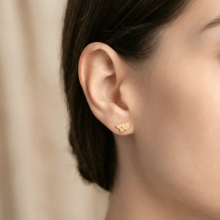 Cercei aur 14K stud trio inimi — close-up cu fluturașii push-back, secvență gradient pe lob