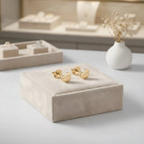 Cercei aur 14K stud cu inimă mică plină 6x6mm — pereche pe pernuță de catifea crem, vitrină cu bijuterii și flori uscate gypsophila pe fundal, finisaj oglindă, prindere fluturaș push-back