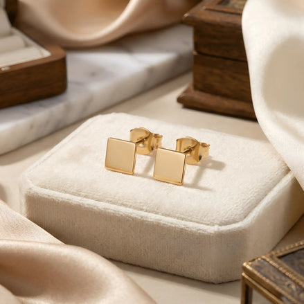 Cercei aur 14K stud pătrat plin — pereche pe cutie velvet ivory cu mătase și marmură, două pătrate perfecte 9x9mm lustruite oglindă, finisaj minimalist geometric