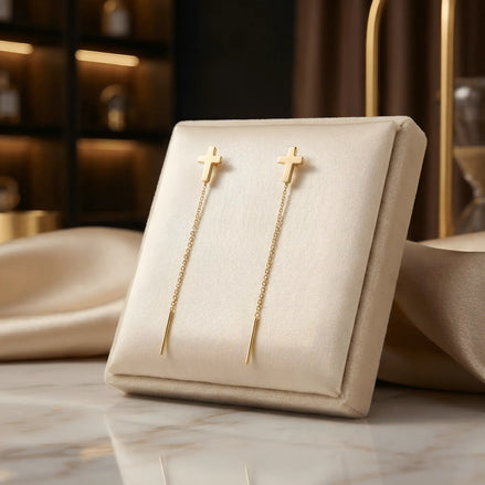 Cercei aur 14K threader cruce mică plină — pereche pe pernă crem cu mătase aurie, cruce latină stilizată și lănțișor delicat 7cm