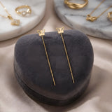 Cercei aur 14K threader fluture decupat — pereche simetrică pe pernă gri catifea, fluturi mici cu aripi decupate, lănțișor delicat 7cm