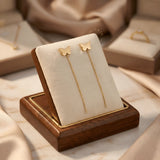 Cercei aur 14K threader fluture mic plin — pereche pe pernă bej, fluture stilizat plin frontal și lănțișor delicat 7cm pe lemn de nuc