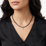 cristale-negre-purtat-la-gat.jpg	Colier elegant cu cristale negre și bile din aur 14K purtat la gât de o femeie.
