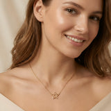 Colier aur 14K stea purtat de damă peste top crem off-shoulder