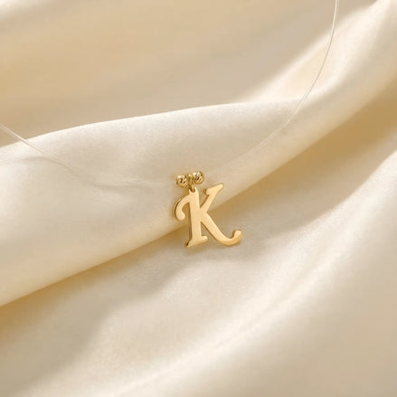 Colier aur 14K cu pandantiv litera K cursivă pe fir transparent — model floating