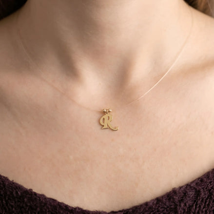 Colier aur 14K litera R — purtat pe decolteu, efect floating pe pielea modelei