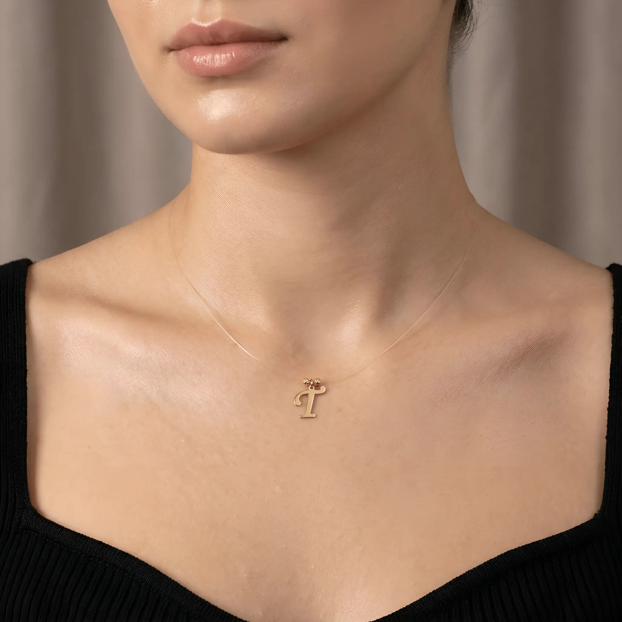 Colier aur 14K litera T — purtat pe decolteu pătrat top negru rib, efect floating