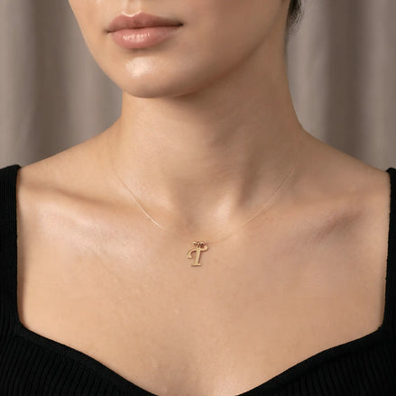 Colier aur 14K litera T — purtat pe decolteu pătrat top negru rib, efect floating