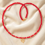 Colier choker aur 14k cu cristale roșii fațetate, bile de aur și pandantiv trifoi cu patru foi, lucrat manual