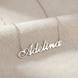 Lănțișor argint 925 rodiat cu numele Adelina, pandantiv decupat 42x10 mm font cursiv inițiala A cu buclă jos-stânga, lanț anchor 46 cm pe textil natural ivory tip in cu pliuri