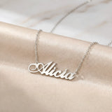 Lănțișor argint 925 rodiat personalizat cu numele Alicia decupat în scriere cursivă elegantă cu A buclat pe drapaj satin roz piersică, lanț subțire alb-platinat