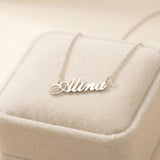 Lănțișor argint 925 rodiat cu numele Alina, pandantiv decupat 34.5x10 mm font cursiv, lanț anchor 46 cm pe cutie velvet bej cu cusătură decorativă