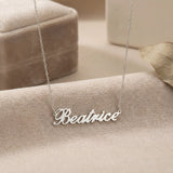 Lănțișor argint 925 rodiat personalizat cu numele Beatrice decupat în scriere cursivă elegantă pe textil bej cu cutie velvet în plan secund, lanț subțire alb-platinat