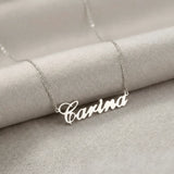 Lănțișor argint 925 rodiat cu numele Carina, pandantiv decupat 38.5x10 mm font cursiv inițiala C deschisă, lanț anchor 46 cm pe textil natural ivory tip in