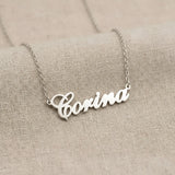 Lănțișor argint 925 rodiat cu numele Corina, pandantiv decupat 38.5x10 mm font cursiv inițiala C deschisă, lanț anchor 46 cm pe textil natural