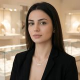 Damă cu păr lung negru purtând lănțișor argint 925 rodiat Eva pe stern peste sacou negru desfăcut, magazin de bijuterii cu vitrine