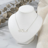 Lănțișor argint 925 rodiat personalizat cu numele Flori decupat în scriere cursivă elegantă cu F și coadă caligrafică pe bust display alb cu eucalipt uscat, lanț subțire alb-platinat