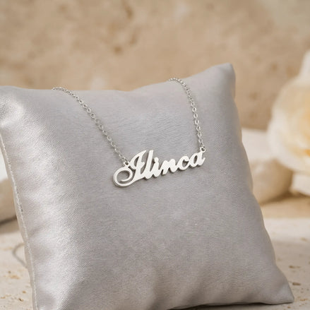 Lănțișor argint 925 rodiat personalizat cu numele Ilinca decupat în scriere cursivă elegantă pe pernuță gri satin cu trandafir, lanț subțire alb-platinat