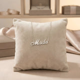 Lănțișor argint 925 rodiat personalizat cu numele Mada decupat în scriere cursivă elegantă cu M cu coadă caligrafică pe pernuță bej display velvet, lanț subțire alb-platinat