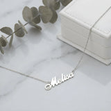 Lănțișor argint 925 rodiat cu numele Melisa, pandantiv decupat 38.5x10 mm font cursiv, lanț anchor 46 cm, lângă cutie cadou albă