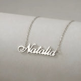 Lănțișor argint 925 rodiat cu numele Natalia, pandantiv decupat 42x10 mm font cursiv inițiala N cu diagonală descendentă, lanț anchor 46 cm pe bust expozițional ivory mat