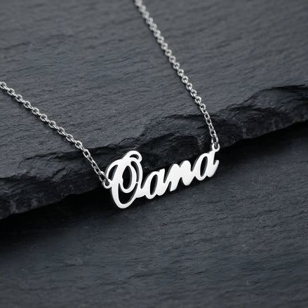 Lănțișor argint 925 rodiat personalizat cu numele Oana decupat în scriere cursivă elegantă cu O mare cu buclă pe stâncă neagră de ardezie, lanț subțire alb-platinat