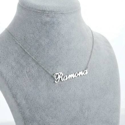 Lănțișor argint 925 rodiat personalizat cu numele Ramona decupat în scriere cursivă elegantă cu R ondulat pe bust display gri velvet, lanț subțire alb-platinat