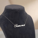 Lănțișor argint 925 rodiat cu numele Simona, pandantiv decupat 38.5x10 mm font cursiv inițiala S cu curbă dublă, lanț anchor 46 cm pe bust expozițional gri-închis