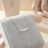 Lănțișor argint 925 rodiat personalizat cu numele Sonia decupat în scriere cursivă elegantă cu S ondulat pe cutie velvet gri în showroom, lanț subțire alb-platinat