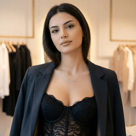 Damă cu păr lung negru purtând lănțișor argint 925 rodiat Vanesa pe stern peste corset negru cu dantelă, sacou bleumarin desfăcut, magazin de modă