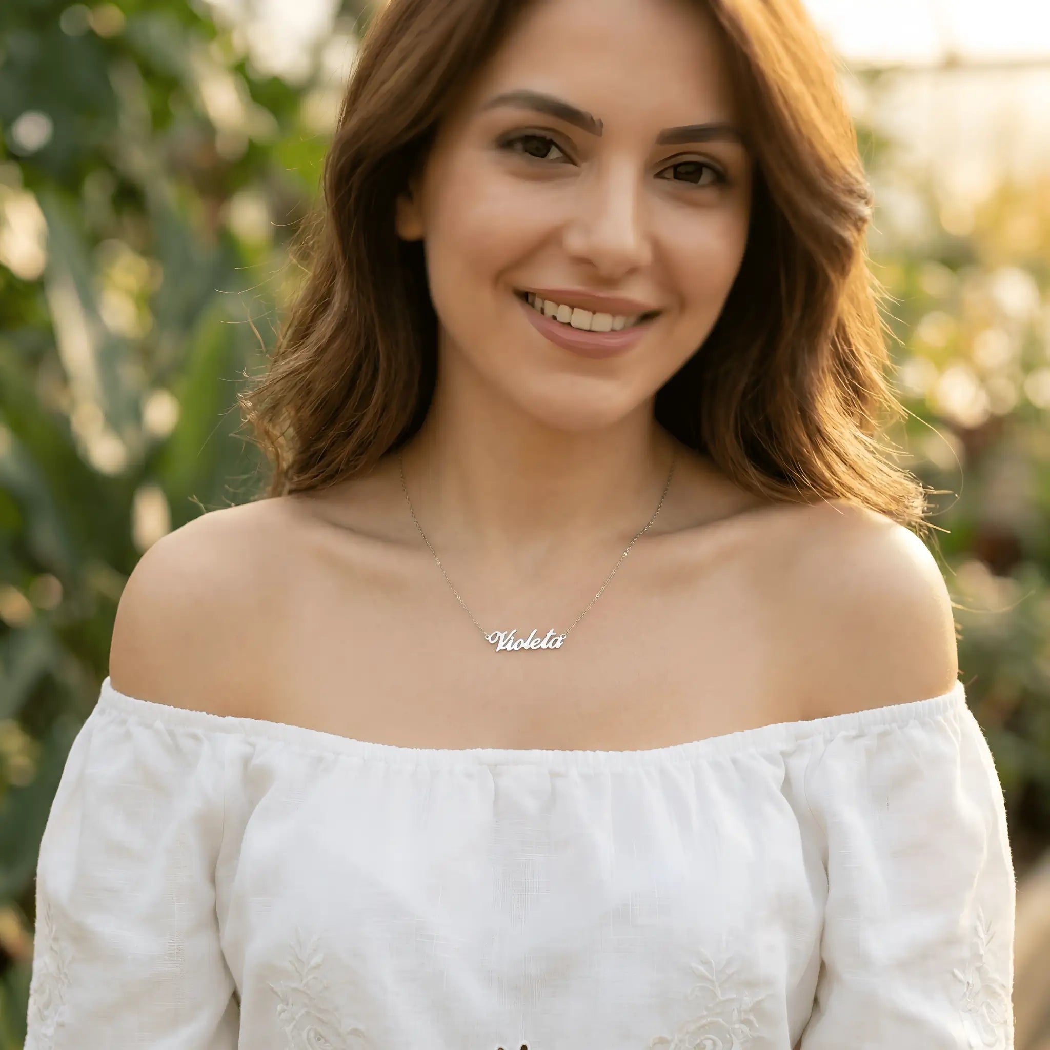 Lănțișor argint 925 cu nume Violeta purtat de damă peste bluză albă off-shoulder cu broderie