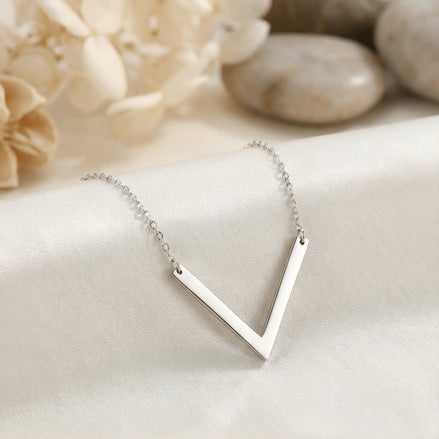 Lănțișor argint 925 rodiat cu pandantiv geometric V din două bare plate drepte sudate la vârf, suspendat orizontal pe lanț subțire alb-platinat, ambianță blanc