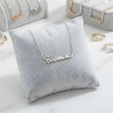 Lănțișor argint 925 rodiat personalizat cu numele Cosmina decupat în scriere cursivă elegantă pe pernuță gri velvet, ambianță jewelry display alb-marmorat