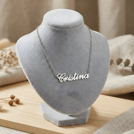 Lănțișor argint 925 rodiat cu pandantiv decupat textul caligrafic Cristina, expus pe bust gri velvet cu decor natural